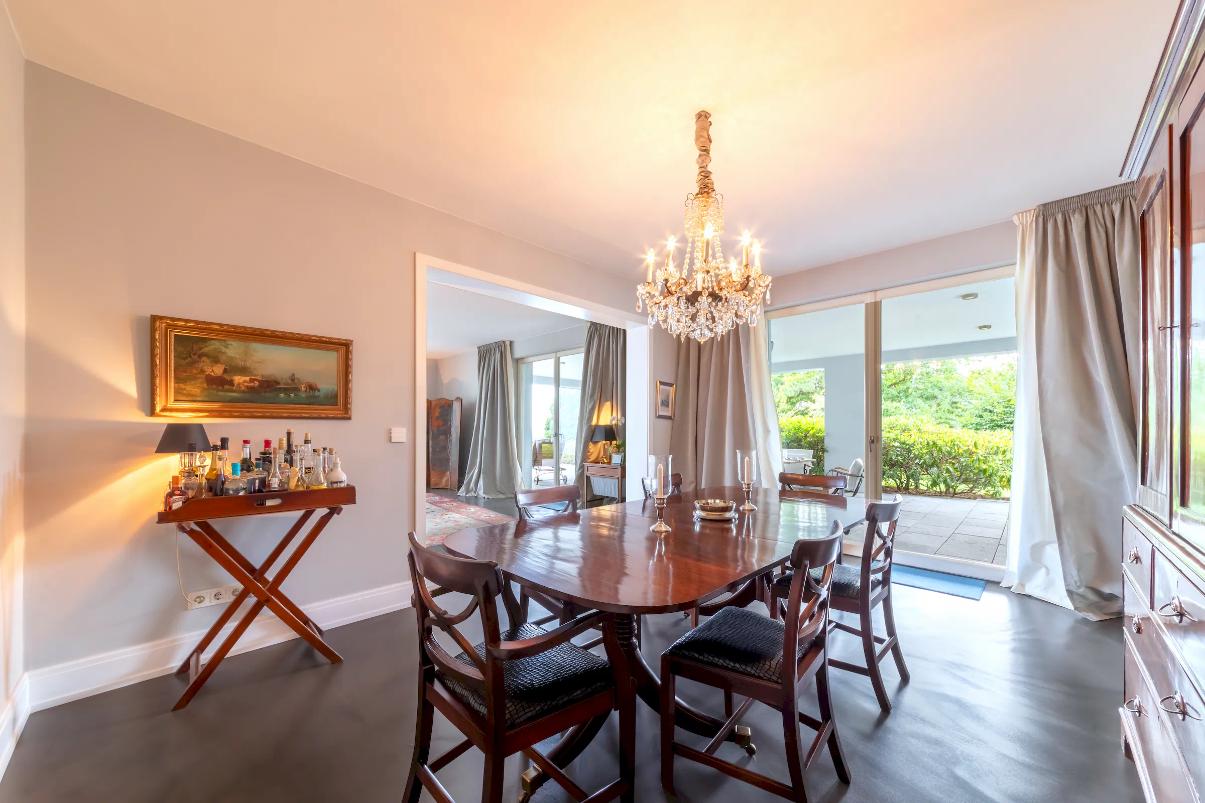 Esszimmer mit großem Esstisch, Natursteinboden und Blick auf die Terrasse in der Villa Sonnenberg