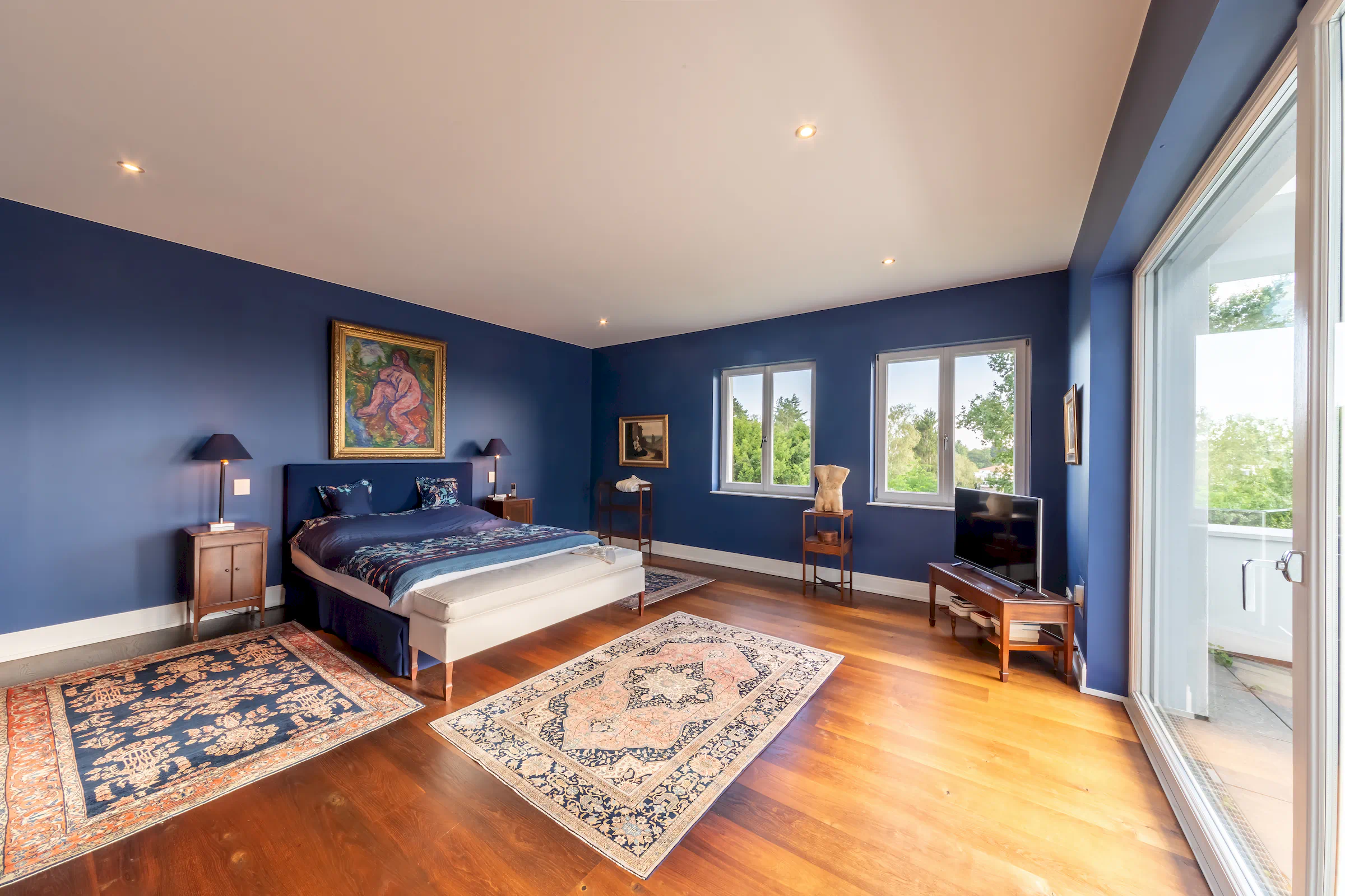 Ruhiges Schlafzimmer mit Holzboden und Blick auf den Garten