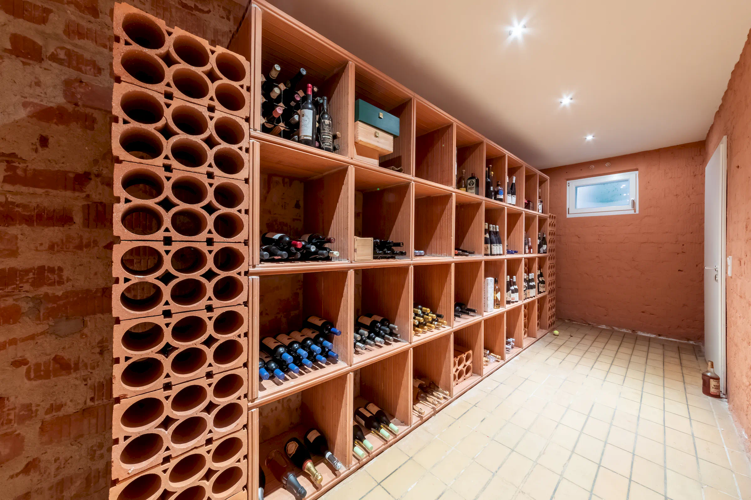 Weinkeller mit Holzregalen und Steinfliesenboden in der Villa Sonnenberg
