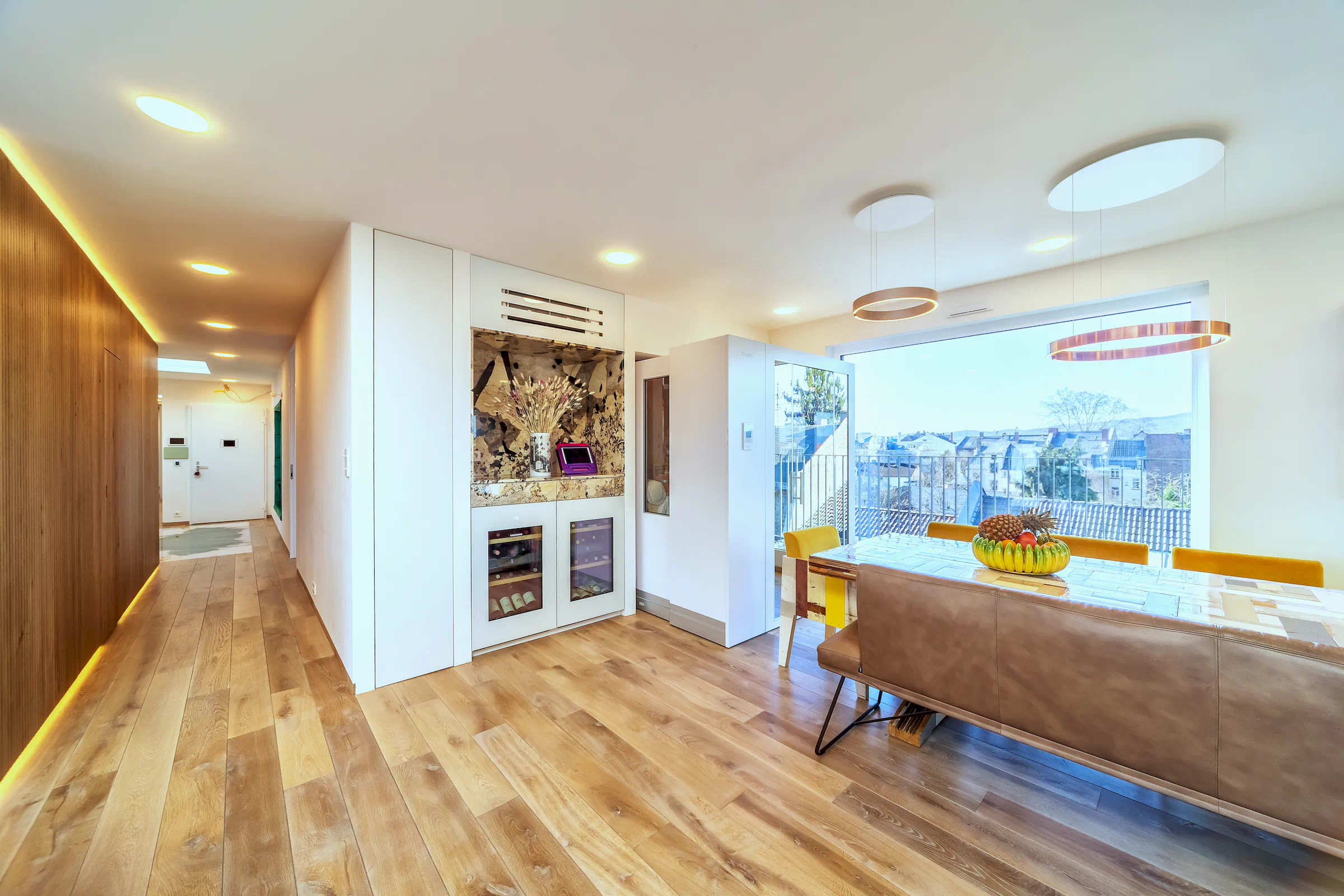 Immobilienfoto Frankfurt – Wohnzimmer mit Weinschränken, Kühlblock und großem Esstisch